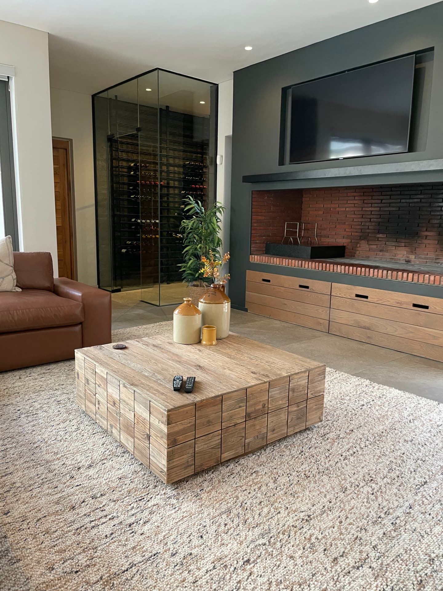 Living room with glazed wine room, brick fireplace and reclaimed timber coffee table