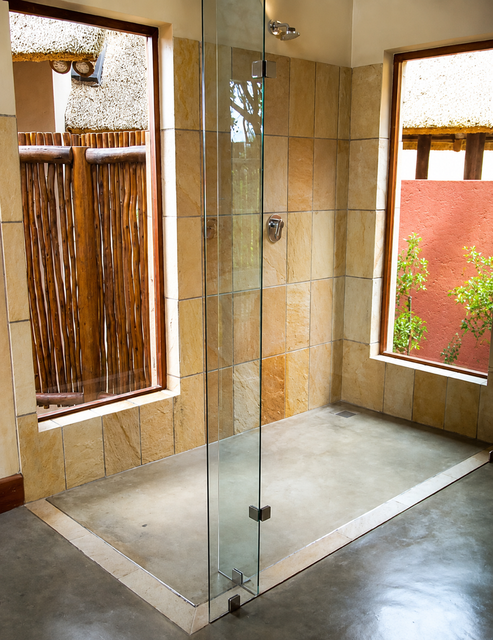 Sandstone-tiled walk-in shower opening onto the bush