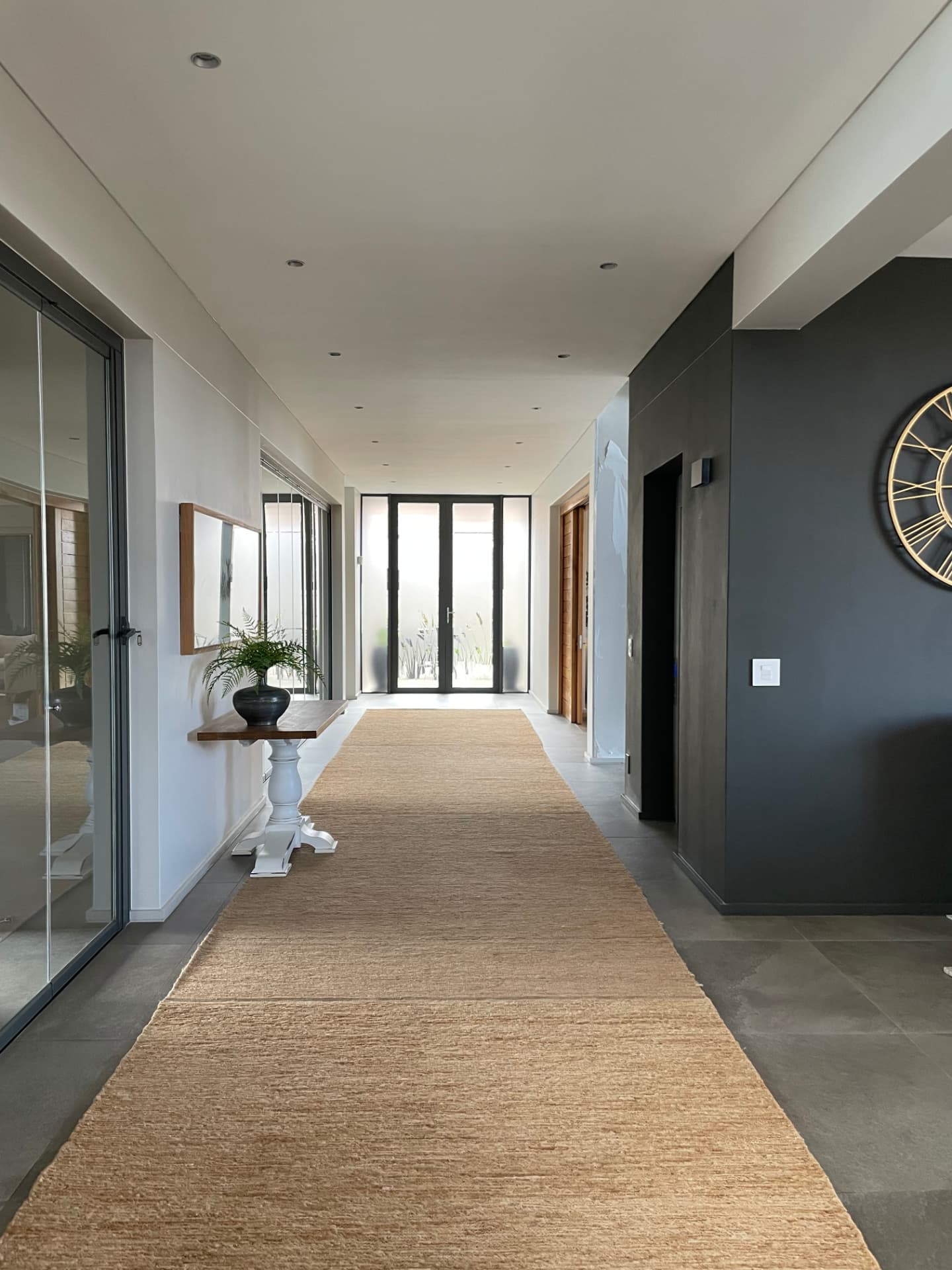 Entrance gallery with jute runner, console table and full-height glazed doors