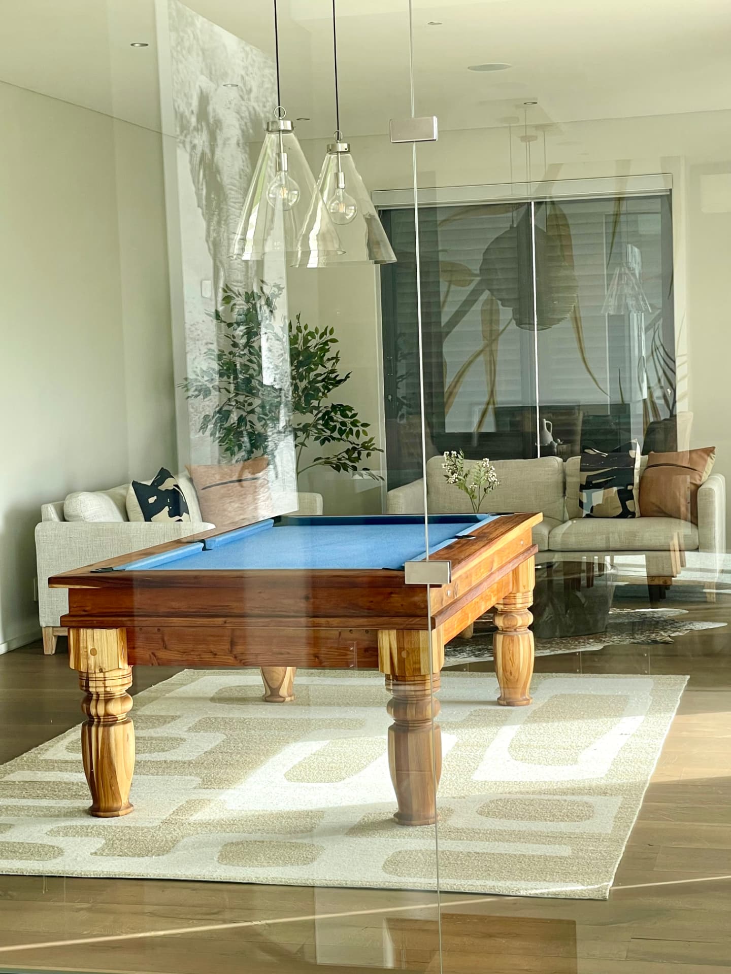 Games room with billiard table, glass pendants and linen seating